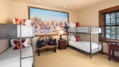 Four bunkbeds in a bedroom with a western theme.
