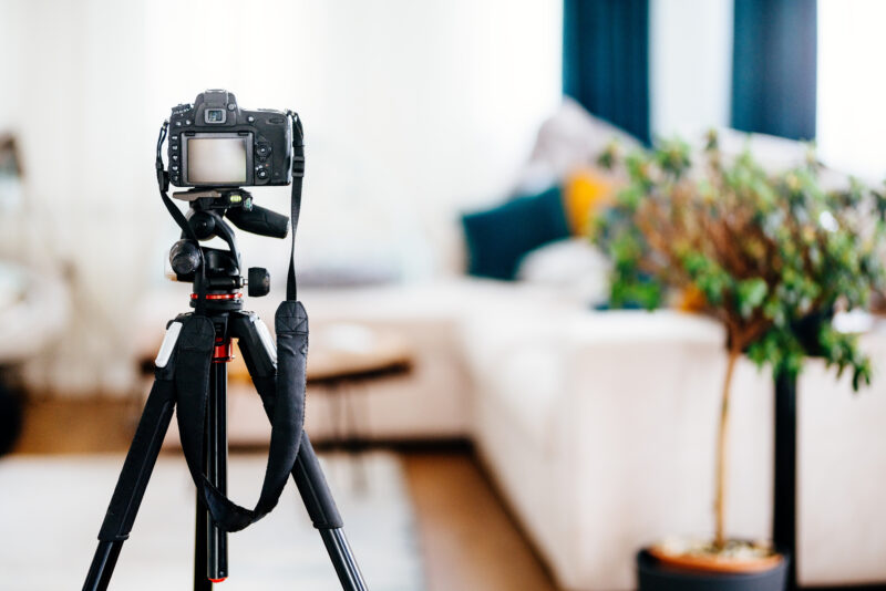 A camera sits on a tripod in a living area of an Airbnb