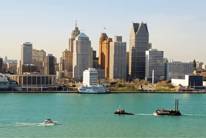 A picture of the water and boats with the Detroit Skyline in the back.
