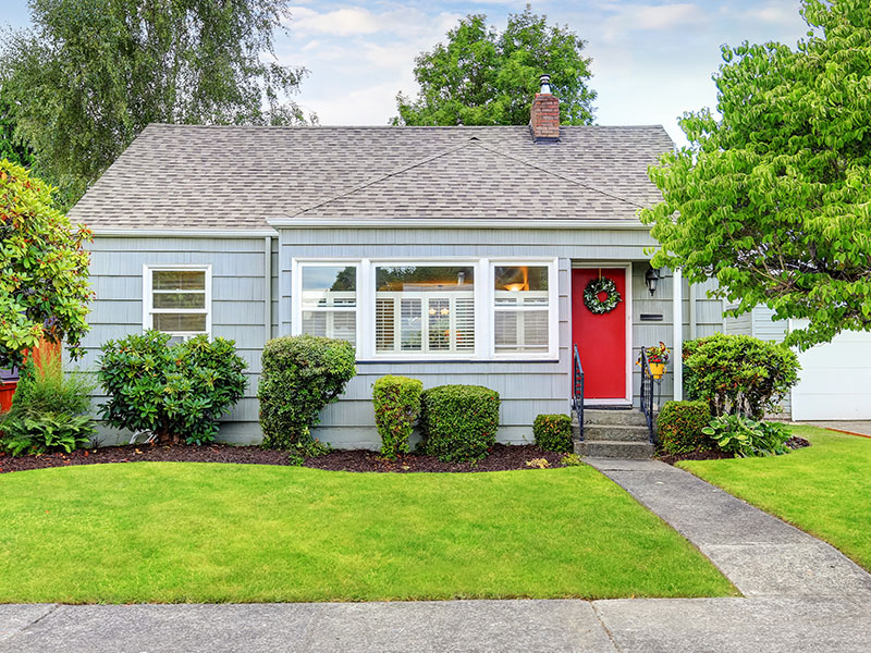 The outside of a short-term rental home with a bright red door.