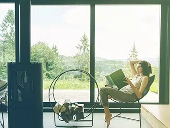 Stylish-Woman-Reading-Book-Sitting-In-Chair-Overlooking Gorgeous Views From Vacation Rental