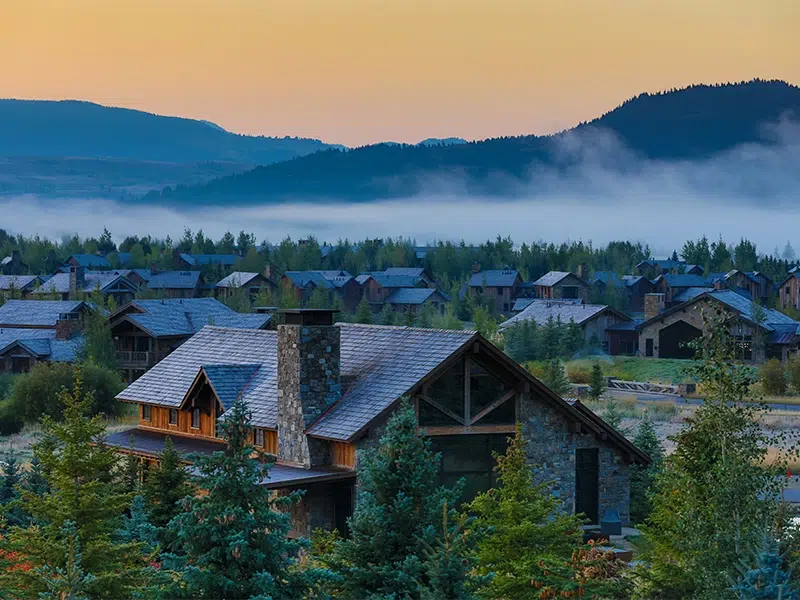 Houses situated in the valley of Wyoming with a morning fog rolling along the mountainside 
